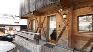 A wooden cabin with a stone foundation, wooden beams, and a number '4' sign. - Casa Col 3, a charming two-room apartment (Cortina d´Ampezzo)