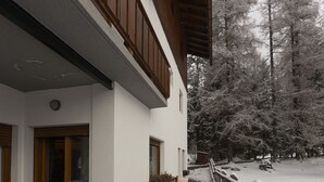 A snow-covered pathway leading to a building with a stone foundation and wooden railings. - Casa Merisanda, comfortable and surrounded by Natur (Cortina d´Ampezzo)