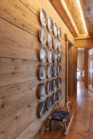 Eine Holzwand mit einer Reihe silberner Teller und einem Holzluder.