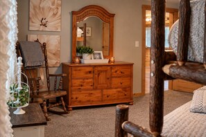 A wooden dresser with a mirror, a chair, and a small table with a candle and a decorative item. - Lakeside! on Lake sleeps 5, close to I 75 interstate, Rest, Relax, Fish, Repeat (Tunnel Hill)