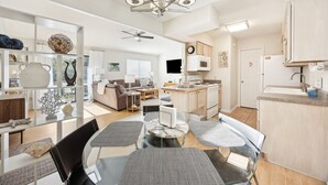 A modern kitchen with a built-in oven, microwave, and sink. There is a dining area with a round table and chairs. - Amelia Island 2 Bedroom Getaway located in Forest Ridge (Fernandina Beach)