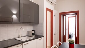 A modern kitchen with white cabinets, a black countertop, and a coffee machine. - Characteristic two-room apartment Colonne di San Lorenzo - Mirable PM (Milano)