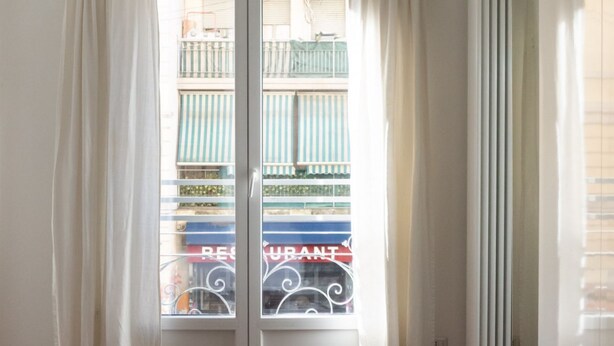 A hotel room with a large window, curtains, and a radiator. - Characteristic two-room apartment Colonne di San Lorenzo - Mirable PM (Milano)