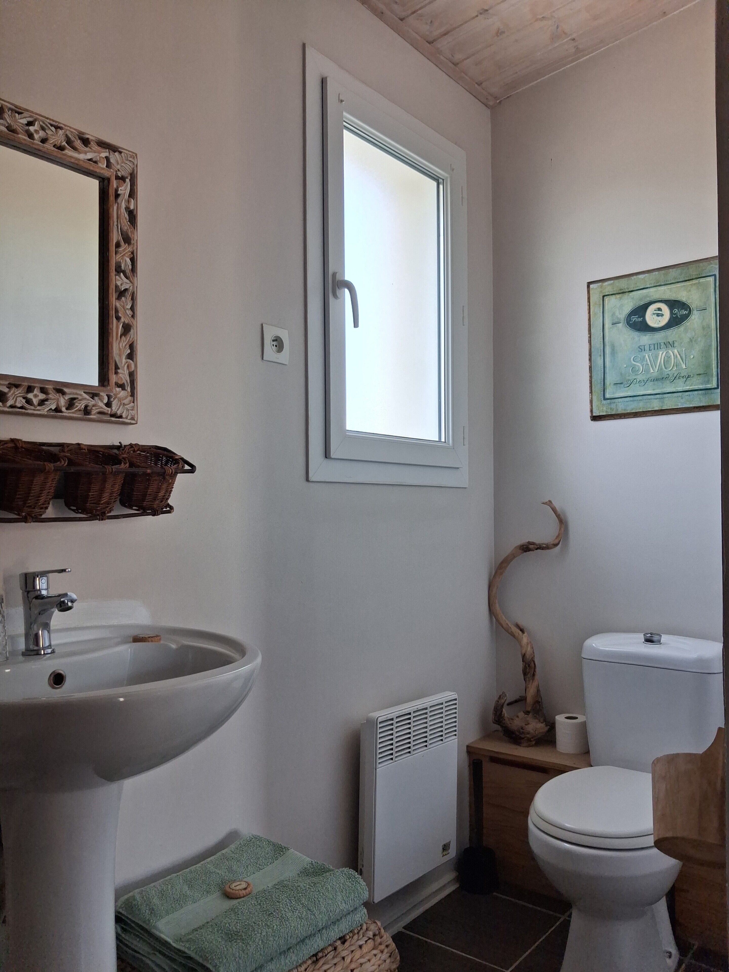 Un baño con lavamanos, inodoro y ventana.