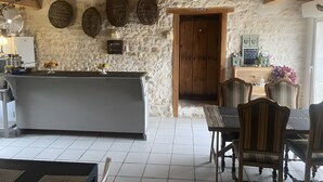 A rustic kitchen with a stone wall, wooden ceiling, and a central island.