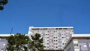 Un edificio de varios pisos con un estilo arquitectónico moderno, que presenta una combinación de tamaños de ventanas y un techo plano.