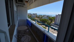 Un balcón con vista a la ciudad y al mar.