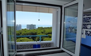 Une pièce avec vue sur une zone côtière, comprenant des bâtiments et de la végétation.