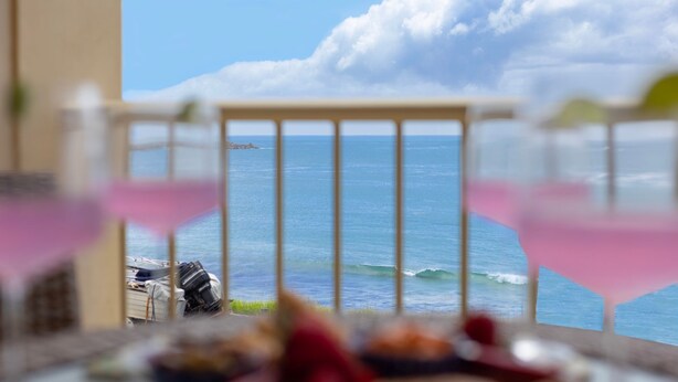 Uma varanda com vista para o oceano e um barco.