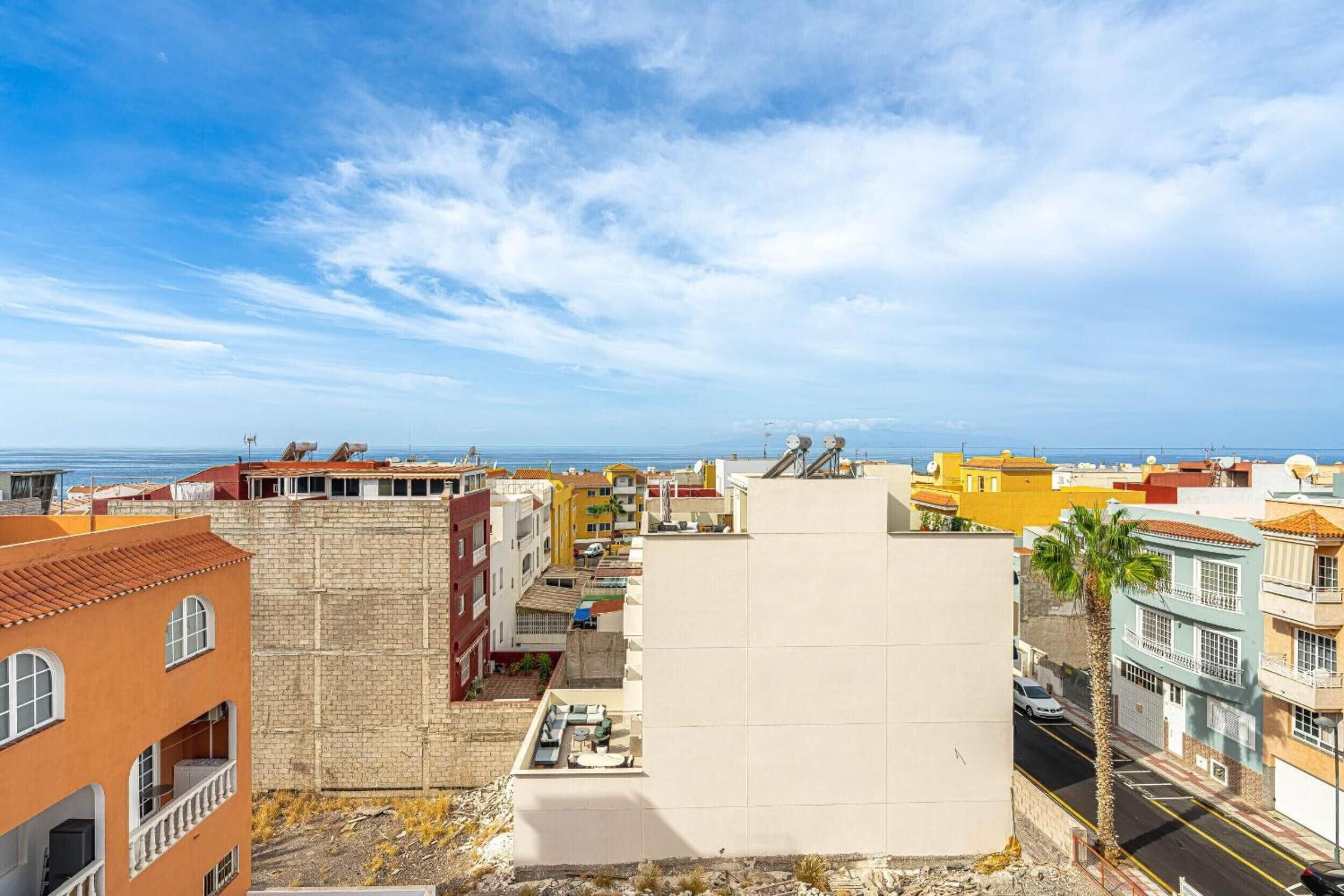 Une zone urbaine côtière avec des bâtiments, un ciel dégagé et une vue sur la mer.
