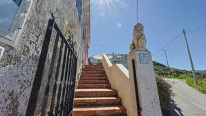 A staircase leading to a building with a stone lion statue at the top, a clear blue sky, and a sign indicating a house number. - Casa Santo Stefano – Panoramic Villa with Sea Views, Pet-Friendly, 6 km from the Beach (Santo Stefano)