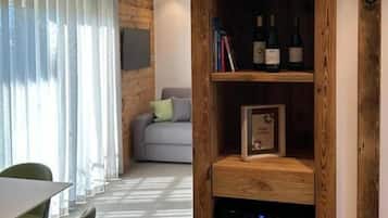Un salon moderne avec une bibliothèque en bois, un canapé gris et un coin repas comprenant des chaises et une table.