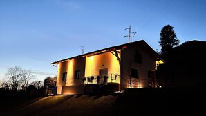 A two-story house with a balcony, a visible power line, and a tree in the background. - ORIGINI HOLIDAYS  (Sedico)