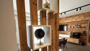 A modern kitchen with wooden accents and built-in shelves displaying kitchenware and decorative items. - ORIGINI HOLIDAYS  (Sedico)