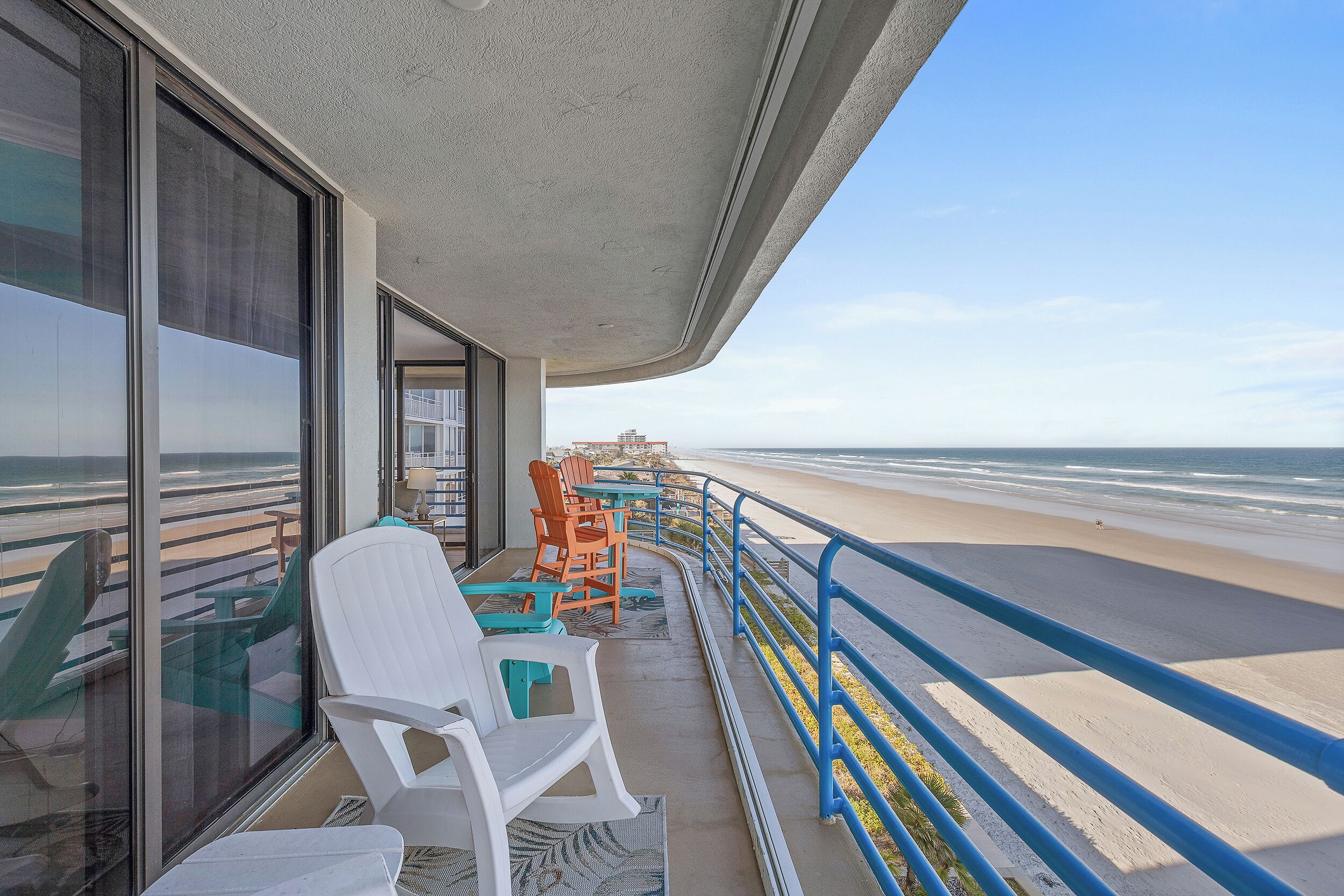 Un balcon avec des chaises donnant sur une plage.