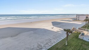 Een uitzicht op het strand met een gebouw naast de kust.
