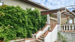 Un escalier menant à une maison dont la façade est en briques et qui est agrémentée d’une rampe métallique.