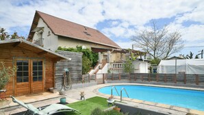 Il s’agit d’une propriété résidentielle dotée d’une piscine, d’une terrasse en bois et d’un patio couvert.