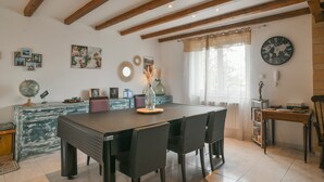 Un coin repas avec une table en bois, des chaises, un globe terrestre et des photos encadrées accrochées au mur.