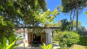 Una piccola casa con un patio, un tavolo e delle sedie.