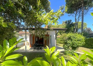 Ein kleines Haus mit einer Terrasse, einem Tisch und Stühlen.