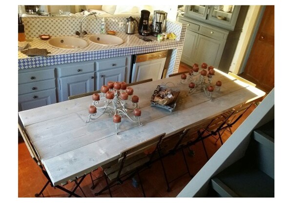 A kitchen with a long counter, two sinks, and a coffee maker.