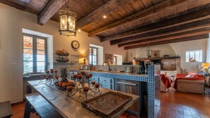A rustic kitchen with a wooden island, tiled backsplash, and exposed beams. - 18th CENTURY STONE BASTIDE in UZES (La Bastide-d'Engras)