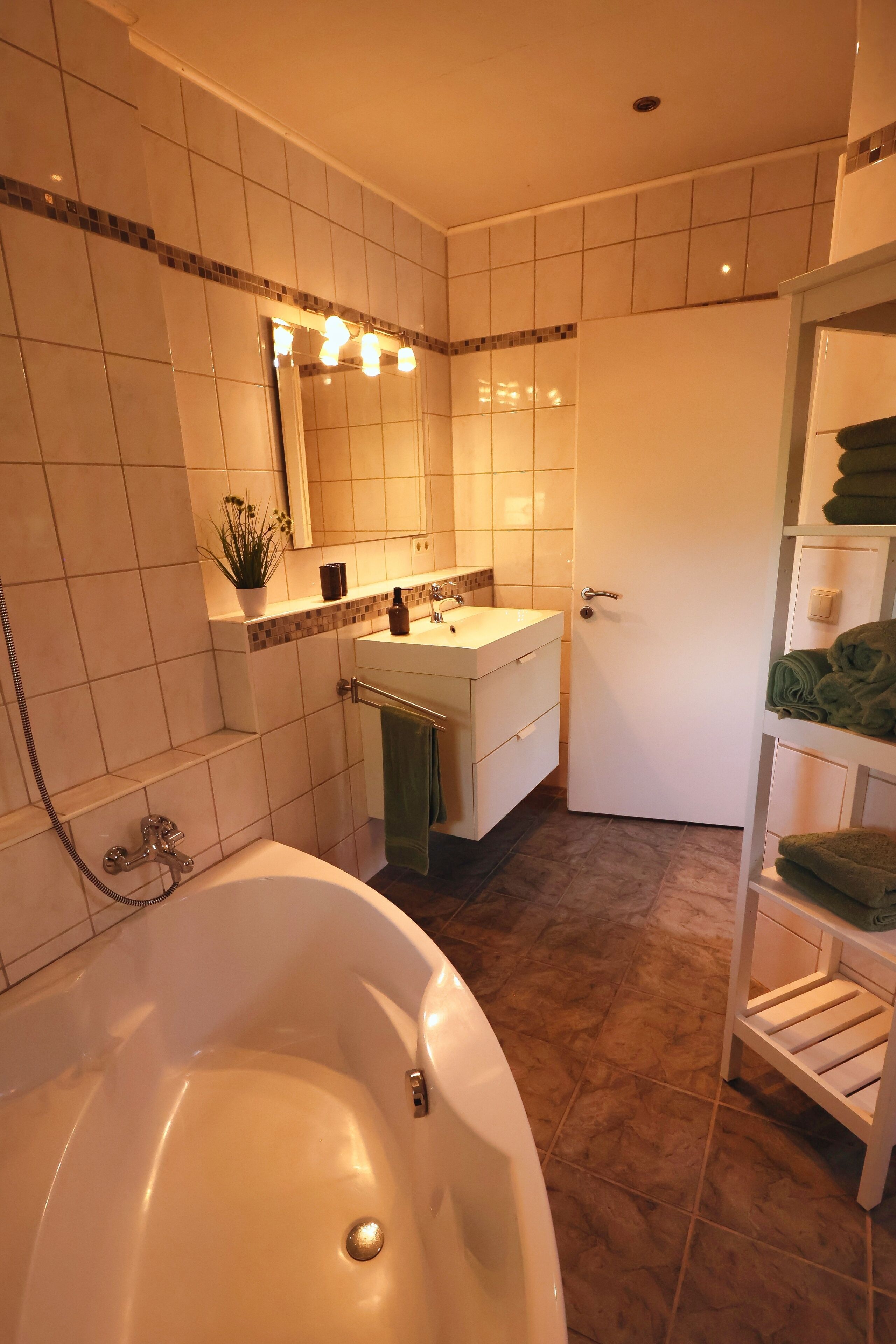 A bathroom with a bathtub, a sink, and a mirror.