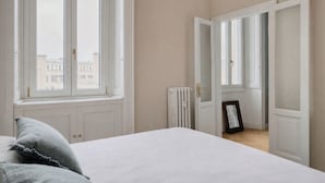 A bedroom with a bed, a window, a radiator, and an open door leading to another room. - Ferrucci 14 by Wynwood House (Milan)