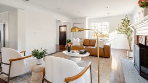 Un salon moderne comprenant un canapé, deux fauteuils, une table basse et une cheminée.