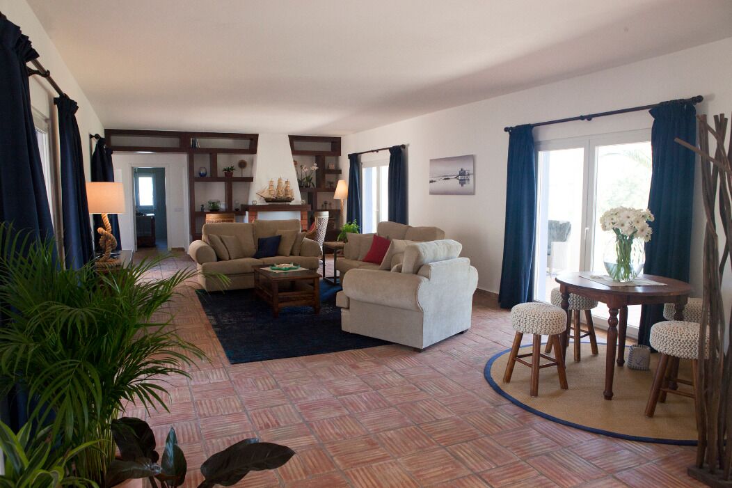 Uma sala de estar espaçosa com sofás, uma mesa de centro e um espaço de jantar com cadeiras.