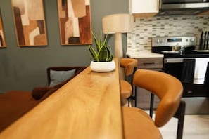 Eine moderne Küche mit einem Holztisch, Stühlen und einem Blumentopf.