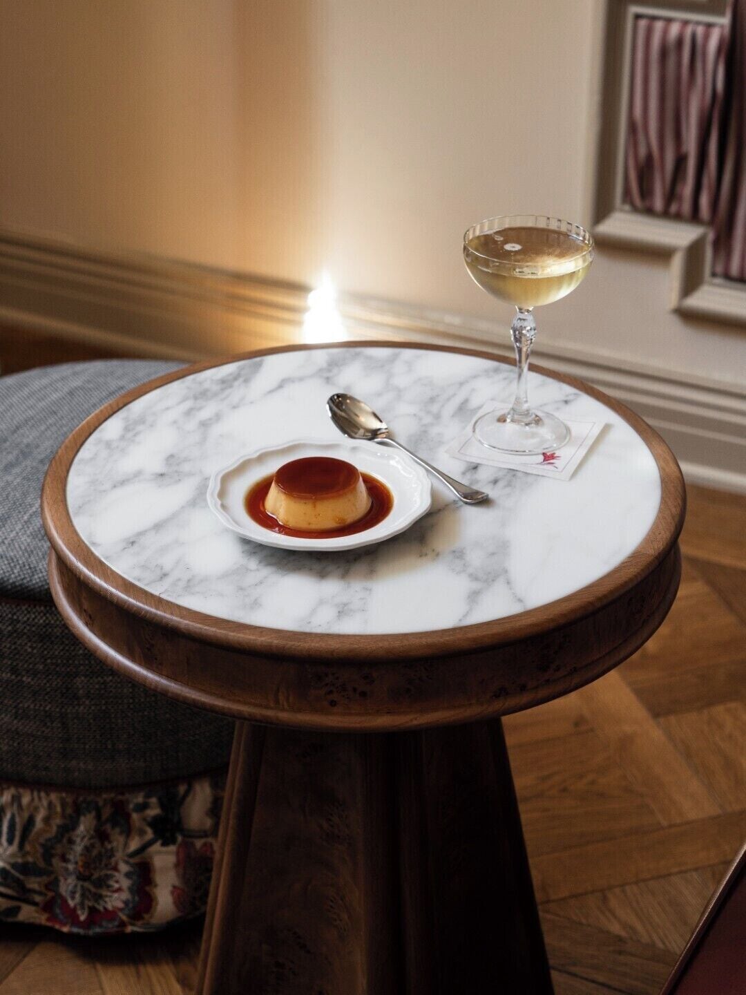 Sobremesa sobremesa em mesa de mármore com uma colher e um copo de vinho branco.