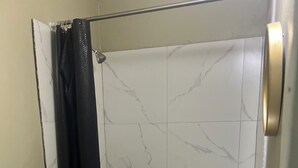 Un bany amb dutxa, vàter i rentapans.