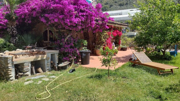 A stone building with a garden, outdoor seating, and a view of a mountain. - Holiday Home 'Piccolo Angolo di Paradiso' with Private Terrace, Garden & Wi-Fi (Taggia)