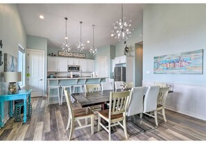 A modern kitchen with white cabinets, a central island, and pendant lighting. - Blue water Bliss at Surfside Spacious 4 bd 4 bath Ocean Front Private Walk Over (Freeport)