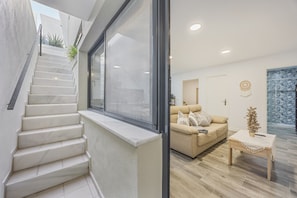 Un intérieur moderne avec un escalier, un canapé et une petite table.