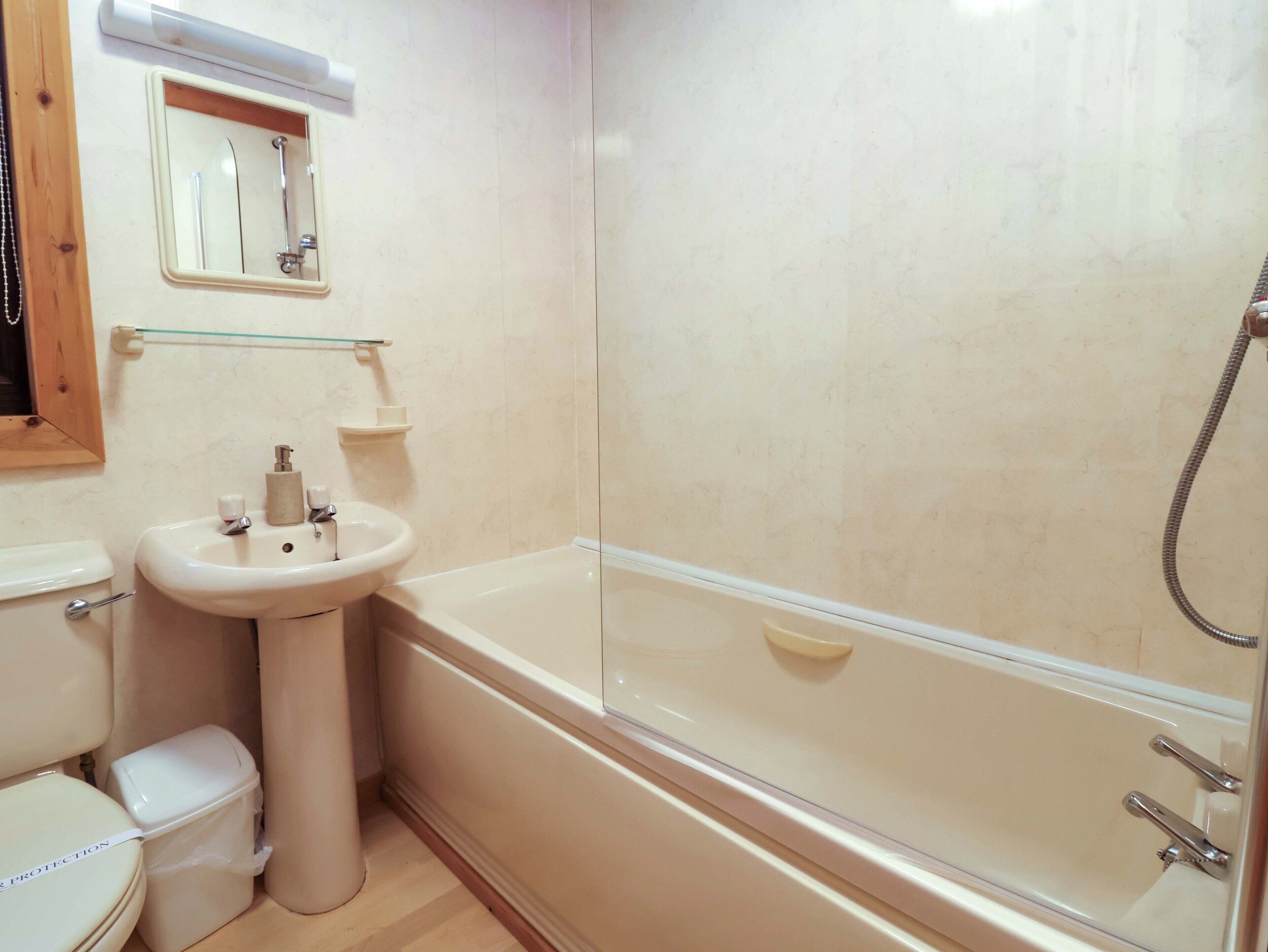 A bathroom with a toilet, sink, and bathtub.