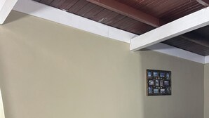 Un coin repas avec une table et quatre chaises, un canapé noir et un collage de photos accroché au mur.