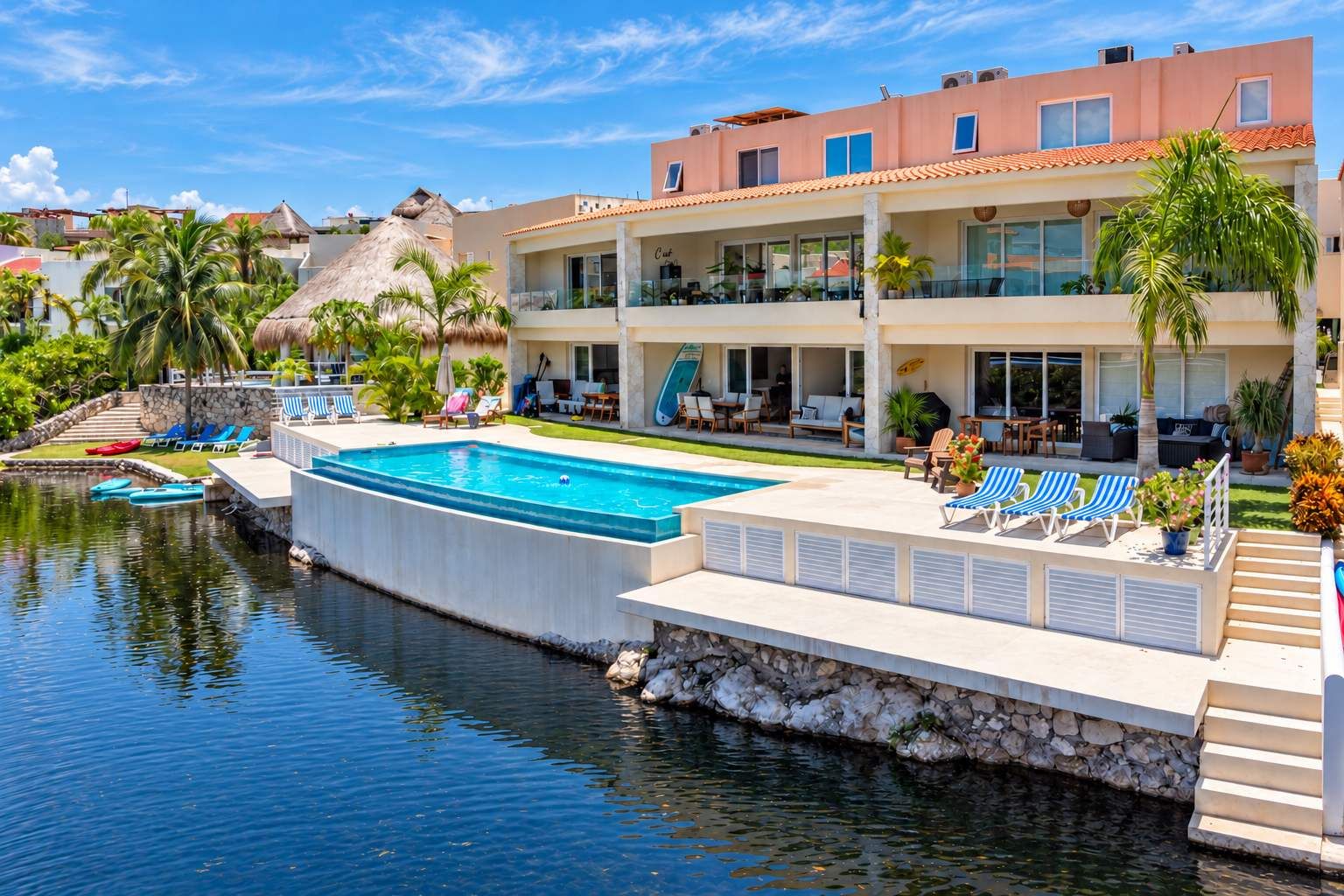 A resort with a swimming pool, lounge chairs, and a view of the water.