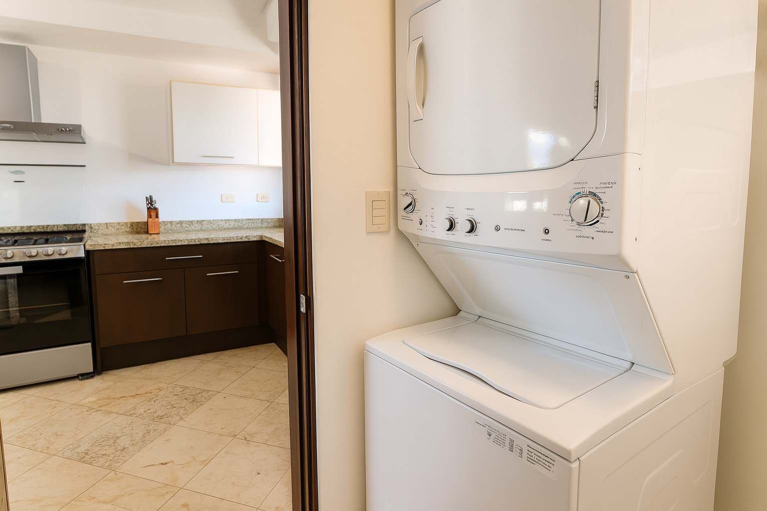 A kitchen with a built-in oven, a stainless steel range hood, and a countertop with a knife block.
