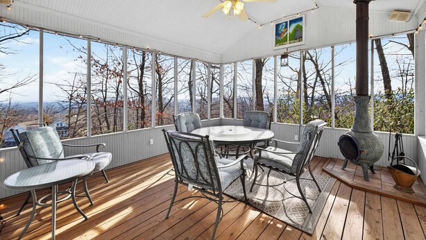 A covered outdoor seating area with a round table and chairs, a ceiling fan, and a decorative chimney. - One-level w/FirePit, 2 Living Areas & Resort Amens (Hedgesville)