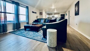 Ein modernes Wohnzimmer mit einem Ecksofa, einem Couchtisch und einem Teppich.