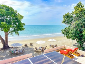 A beachside view with a pool area, sun loungers, and umbrellas. - Hotel Stanza del Mar (Coveñas)