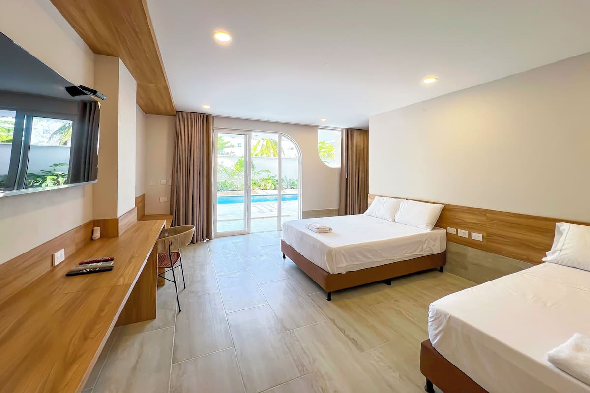 Une chambre d’hôtel avec un lit, un bureau, une chaise et un téléviseur.