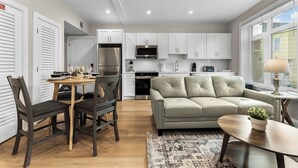 A modern kitchen with white cabinets, a stainless steel refrigerator, and a built-in oven. - Luxury 2bd/2ba near Cabmridge 64fp (Somerville)