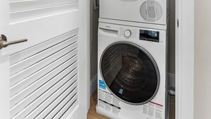 A laundry room with two stacked front-loading washing machines. - Luxury 2bd/2ba near Cabmridge 64fp (Somerville)