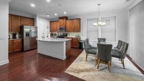 A modern kitchen with wooden cabinets, stainless steel appliances, and a central island. - 3 King Bdrs - Modern Fully Equipped Upscale House (Charlotte)