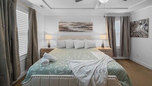 A bedroom with a bed, two bedside tables, a ceiling fan, and a painting on the wall. - 3 King Bdrs - Modern Fully Equipped Upscale House (Charlotte)