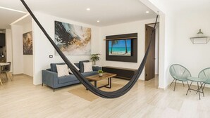 Una sala de estar moderna con una hamaca, un sofá, una mesa de centro y un televisor.